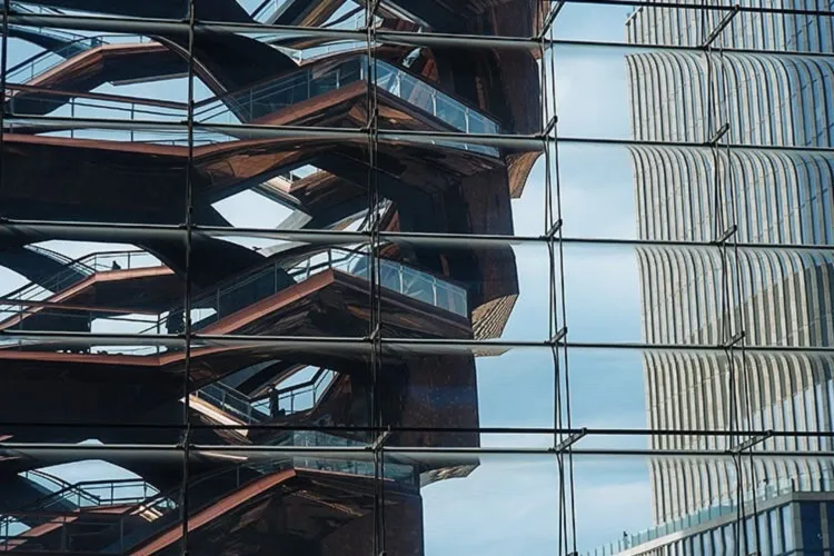 The Vessel at Hudson Yards viewed reflected in the glass facade of one of the buildings