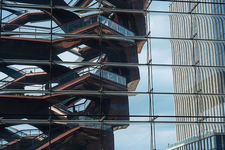The Vessel at Hudson Yards viewed reflected in the glass facade of one of the buildings