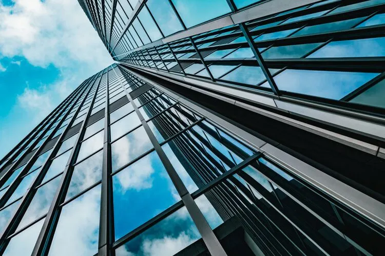 Office towers made of glass with the blue sky reflecting from their windows